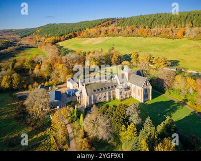 Pluscarden Abbey un monastero cattolico benedettino vicino a Elgin in Scozia circondato da alberi dai colori vivaci durante il sole autunnale Foto Stock