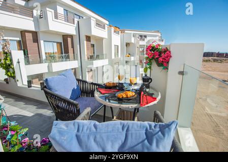 Terrazza con balcone di un lussuoso appartamento in un resort tropicale con mobili e vista dal tavolo della colazione Foto Stock