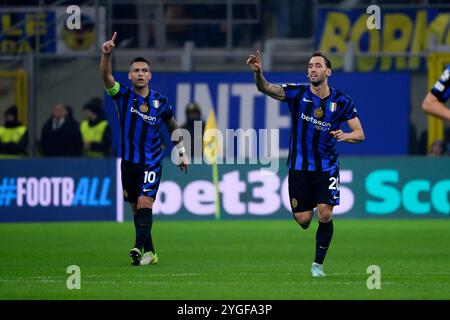 Lautaro Martinez e Hakan Calhanoglu del FC Internazionale reagiscono dopo il gol del 1-0 durante la partita di calcio di UEFA Champions League 2024/2025 tra FC Internazionale e Arsenal FC allo stadio San Siro di Milano (Italia), 6 novembre 2024. Foto Stock