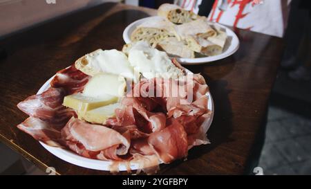 Tagliere di salumi e formaggi con tapas tradizionali spagnole - jamon serrano, lomo e fette di vari formaggi - servito su un tavolo di legno con pane. Ciao Foto Stock