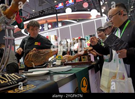 Shanghai. 6 novembre 2024. I visitatori si allineano per assaggiare il prosciutto spagnolo durante la settima China International Import Expo (CIIE) nella zona orientale di Shanghai, 6 novembre 2024. Crediti: Liu Ying/Xinhua/Alamy Live News Foto Stock