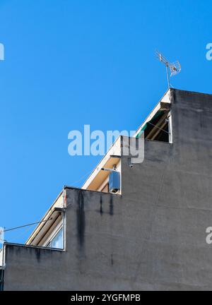 Tetto Cascade con antenna TV contro Clear Blue Sky in un edificio d'epoca. Foto Stock