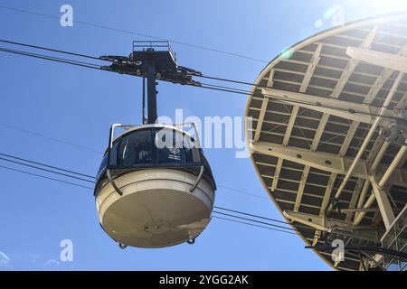 Vista dal basso con raggi di sole di una cabina che parte dalla stazione Pavillon dello Skyway Monte bianco per la vetta Pointe Helbronner, Courmayeur, Italia Foto Stock