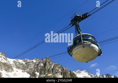 Vista ad angolo basso di una cabina della funivia Skyway Monte bianco che porta gli escursionisti a Pointe Helbronner sul massiccio del Monte bianco, Courmayeur, Aosta, Italia Foto Stock