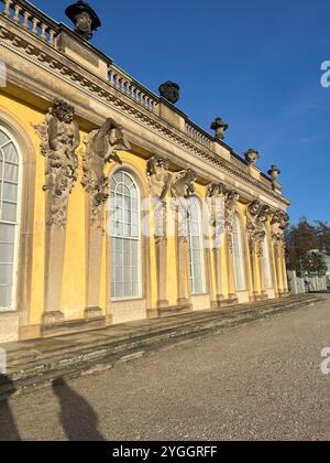 Questa foto cattura la magnifica vista sulla strada del Palazzo Sanssouci, evidenziando la sua grandiosa architettura barocca e i lussureggianti dintorni di Potsdam, Ger Foto Stock