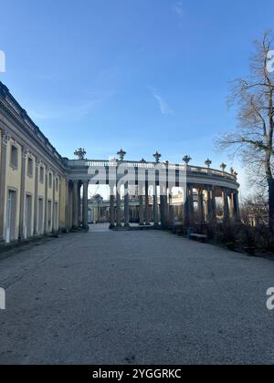 Questa foto cattura la magnifica vista sulla strada del Palazzo Sanssouci, evidenziando la sua grandiosa architettura barocca e i lussureggianti dintorni di Potsdam, Ger Foto Stock