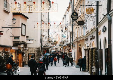 Austria, Salisburgo, 12.01.2023 strade trafficate della città con gente a piedi e negozi. La strada è costeggiata da negozi e ha un'atmosfera festosa con Chri Foto Stock