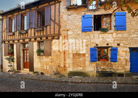 Facciata di case in pietra con porte in legno e finestre blu nella città di Bergerac, Francia Foto Stock