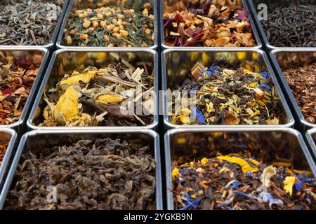 Un vivace assortimento di tè a foglia libera in scatole metalliche, con miscele verdi, nere, oolong, rooibos e erbe. Ricco di colore e aroma. Foto Stock