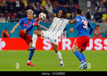 Bucarest, Romania. 7 novembre 2024. Octavian Popescu (L) e Risto Radunovic (R) della FCSB si scontrano con Kevin Mbabu del Midtjylland durante una partita di UEFA Europa League tra FCSB e Midtjylland a Bucarest, Romania, 7 novembre 2024. Crediti: Cristian Cristel/Xinhua/Alamy Live News Foto Stock