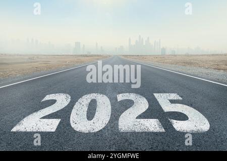 iscrizione 2025 scritta su strada autostradale in mezzo a strada asfaltata vuota e bel cielo blu. Concetto per VISION nuovo anno 2025. visione futura. Foto Stock