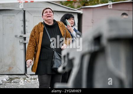 ZAPORIZHZHIA, UCRAINA - 7 NOVEMBRE 2024 - Una donna piange fuori da una sezione di un condominio distrutto da una bomba guidata russa, Zaporizhzhia, Ucraina sudorientale. Otto persone, tra cui un bambino di un anno, sono morte e 42 sono rimaste ferite dopo che le truppe russe hanno attaccato Zaporizhzhia con cinque bombe guidate. Foto Stock