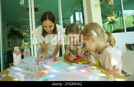 L'insegnante in officina ha messo in tecnica due ragazze come assemblare un mosaico termico Foto Stock