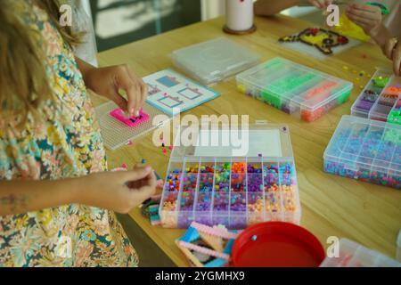 L'insegnante in officina ha messo in tecnica due ragazze come assemblare un mosaico termico Foto Stock