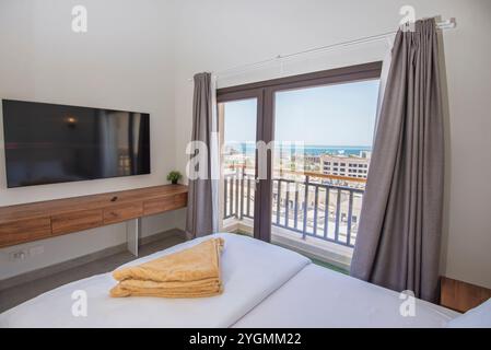 Arredi di design interno, arredi di lusso, camera da letto con mobili e letto matrimoniale con vista sul mare Foto Stock