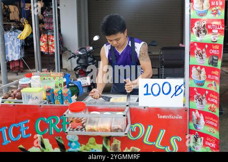 Il tizio thailandese fa il gelato al mango per strada Foto Stock