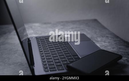 Ampio angolo di visione del computer portatile desktop con smartphone. Luogo di lavoro con spazio vuoto per il testo. Foto Stock