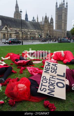 Londra, Regno Unito. 8 novembre 2024. Gli attivisti per il clima Fossil Free London mettono in scena un morto fuori dalle Houses of Parliament per chiedere al governo di fermare il giacimento petrolifero di Rosebank. La decisione di approvare questo giacimento petrolifero è stata contestata da upLIFT e Greenpeace nella Corte di sessione, la suprema corte civile scozzese, a partire dal 12 novembre 2024. Foto Stock