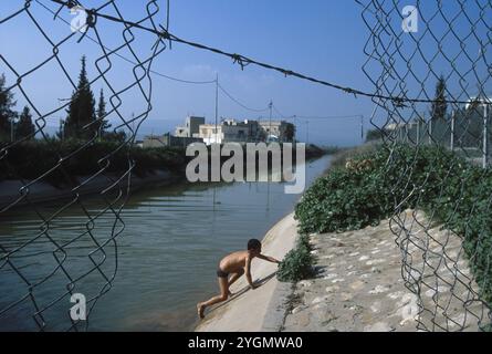 Ragazzo che sale sulle rive del fiume, Yarmuk River, Jordan Valley, Jordan Foto Stock