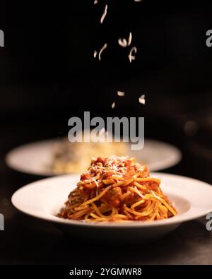 Classici spaghetti italiani conditi con una ricca salsa di pomodoro rosso e una fresca foglia di basilico, un piatto semplice ma saporito che incarna la cucina italiana. Foto Stock