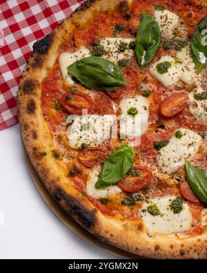 Tradizionale pizza Margherita condita con mozzarella fresca, foglie di basilico e una ricca salsa di pomodoro Foto Stock