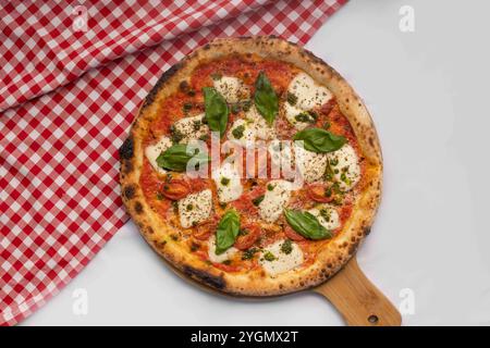 Tradizionale pizza Margherita condita con mozzarella fresca, foglie di basilico e una ricca salsa di pomodoro Foto Stock