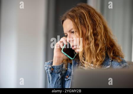 Ritratto di una donna che parla al telefono cellulare Foto Stock