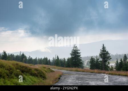 I monti Karkonosze avvolti dalla nebbia creano un paesaggio mistico di cime nebbiose e valli nascoste. Foto Stock