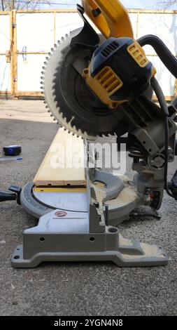 troncatrice in piedi su asfalto nel cortile, oggetto senza persone, lavorazione di materiale in legno per la costruzione in una casa privata Foto Stock