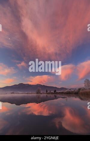 Atmosfera nuvolosa, alba, montagne che si riflettono nel lago, inverno, hoarfrost, Loisach-Lake Kochel Moor, dietro Herzogstand, Heimgarten, Baviera, Germania, Europa Foto Stock