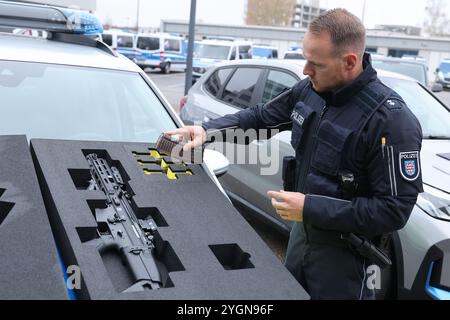 Erfurt, Germania. 8 novembre 2024. Il sovrintendente di polizia Alexander Albinus riempie le munizioni per il nuovo fucile a medio raggio della polizia della Turingia in una borsa durante una conferenza stampa dell'Ufficio di Stato per le indagini criminali. Oltre 1000 fucili del produttore belga FN Herstal sono stati acquistati di recente. Le armi a medio raggio sono usate dalla polizia quando si tratta di colpire bersagli distanti. Credito: Bodo Schackow/dpa/Alamy Live News Foto Stock