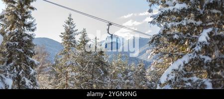 Bansko, Bulgaria, 3 febbraio 2022: Stazione invernale con cabine di risalita e montagne innevate e alberi dopo la nevicata, striscione, Europa Foto Stock