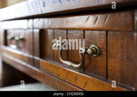 Ferro da stiro con manico vintage su un cassetto antico marrone, interno della casa, primo piano Foto Stock