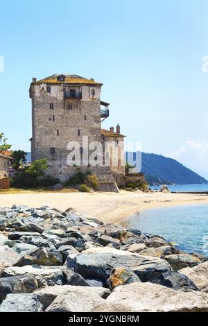 Antica torre di Ouranoupolis sulla penisola di Athos in Halkidiki, Grecia, molo, riva del mare e acqua del Mar Egeo, Europa Foto Stock