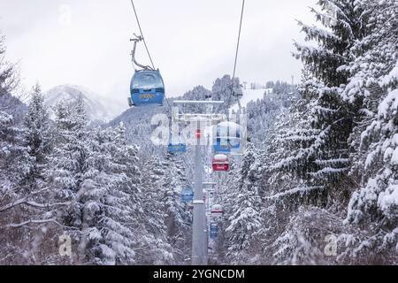 Bansko, Bulgaria, 21 gennaio 2024: Panorama invernale sulla stazione sciistica con cabine di risalita blu, pinete innevate, vista sulle cime delle montagne, Europa Foto Stock