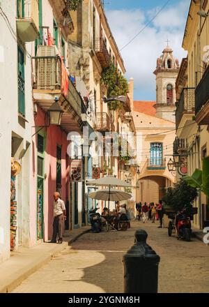 L'Avana, Cuba, 2024 aprile. Vecchi edifici di architettura coloniale nella via dell'Avana Vecchia, Plaza de la Catedral sullo sfondo. Questo iconico monumento dell'UNESCO Foto Stock