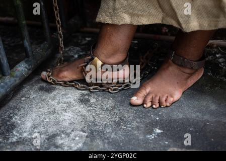 Dettaglio dei piedi incatenati di una donna nera a Pelourinho. Schiavitù in Brasile. Rappresenta la schiava Anastacia. Foto Stock