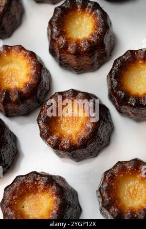 Canneles de bordeaux, dolce tradizionale francese con sfondo bianco Foto Stock