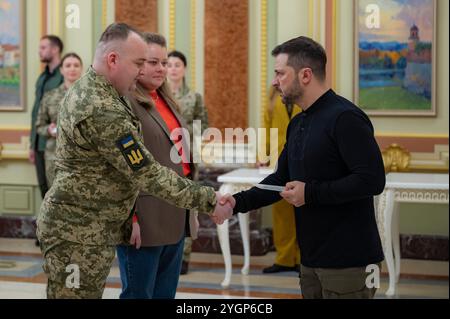 Kiev, Ucraina. 8 novembre 2024. Il presidente ucraino Volodymyr Zelenskyy, a destra, presenta i certificati per appartamenti gratuiti agli eroi dell'Ucraina e ai familiari dei guerrieri caduti durante una cerimonia al Palazzo Mariinskyi, 8 novembre 2024 a Kiev, Ucraina. Credito: Presidenza Ucraina/Ufficio stampa presidenziale ucraino/Alamy Live News Foto Stock