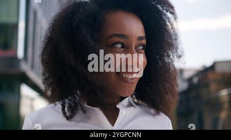 Felice eccitata ragazza afroamericana gioiosa studentessa donna d'affari donna festeggia i risultati all'aperto il successo vincere la carriera dei lavoratori Foto Stock