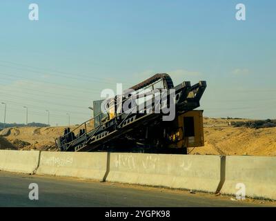 Giza, Egitto, ottobre 25 2024: I camion da costruzione pesanti per lo sviluppo vicino alla strada sulla tangenziale di Giza, progetti immobiliari egiziani e. Foto Stock