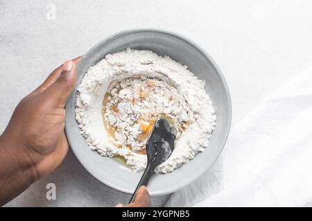 Vista dall'alto dell'impasto della torta di luna mescolato, vista dall'alto dell'impasto fatto in casa della torta di luna in una ciotola grigia, processo di preparazione delle torte di luna per il festival di metà autunno Foto Stock