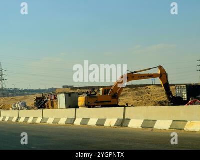 Giza, Egitto, ottobre 25 2024: I camion da costruzione pesanti per lo sviluppo vicino alla strada sulla tangenziale di Giza, progetti immobiliari egiziani e. Foto Stock