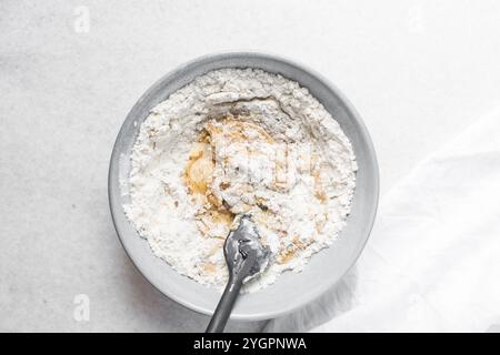 Vista dall'alto dell'impasto della torta di luna mescolato, vista dall'alto dell'impasto fatto in casa della torta di luna in una ciotola grigia, processo di preparazione delle torte di luna per il festival di metà autunno Foto Stock