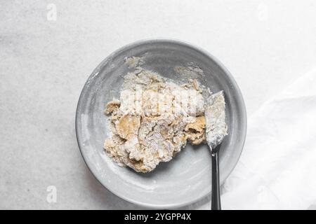 Vista dall'alto dell'impasto della torta di luna mescolato, vista dall'alto dell'impasto fatto in casa della torta di luna in una ciotola grigia, processo di preparazione delle torte di luna per il festival di metà autunno Foto Stock