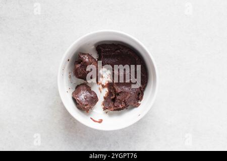 Vista dall'alto delle palline di pasta di fagioli rossi in un recipiente bianco, vista dall'alto delle palline di pasta dolce di fagioli adzuki in un piatto bianco, processo di preparazione delle torte di luna Foto Stock