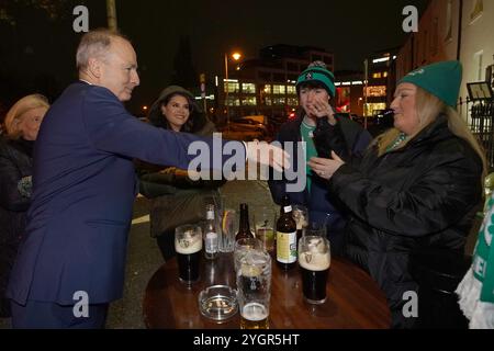 Il leader di Tanaiste e Fianna Fail Micheal Martin saluta i tifosi di rugby al Bridge pub di Ballsbridge, Dublino, prima della partita di rugby irlandese fuori dallo stadio Aviva di Dublino, mentre la campagna elettorale inizia per le elezioni generali del 29 novembre. Data foto: Venerdì 8 novembre 2024. Foto Stock