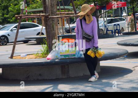Pattaya, Tailandia - 5 ottobre 2024: Bali hai, Una donna venditrice di strada thailandese, stava aspettando che i turisti vendessero loro frutta. Foto Stock