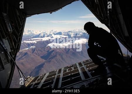 2 ottobre 2024 - Joint base Elmendorf-Richardson, Alaska, USA - Alaska Air National Guard Tech. Il sergente Jeremy Rhodes, un comandante del carico HC-130J Combat King II assegnato al 211th Rescue Squadron, osserva il paesaggio mentre conduce operazioni di addestramento aviotrasportato sulla Joint base Elmendorf-Richardson, Alaska, 2 ottobre 2024. Il Combat King utilizza l'avionica avanzata per localizzare personale isolato da altitudini più elevate e può inserire personale di soccorso tramite cadute a bassa e alta quota. Il 211th RQS, insieme al 210th e al 212th RQS, costituiscono la 176th Wing Rescue Triad e sono tra i combattimenti più impegnati Foto Stock