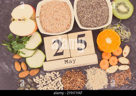 Calendario cubo con data del giorno Mondiale della tiroide e il miglior cibo contenente minerali naturali e vitamine per la tiroide sana Foto Stock